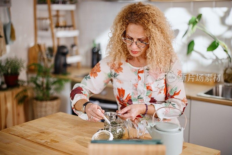 一位女士在茶道上为自己准备了一杯新鲜的有机茶。