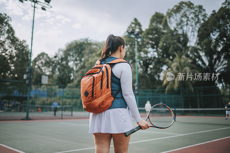 后视镜亚洲中国中年女子网球运动员等待看着网球场