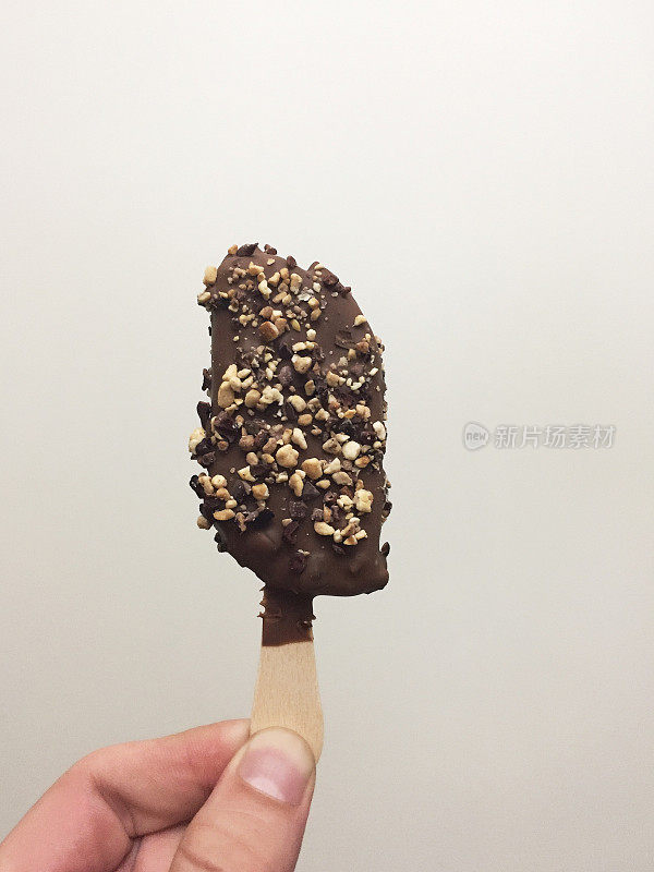 手里拿着巧克力盖着开心果冰淇淋，吃着冰淇淋