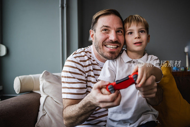 一个小男孩和他父亲一起玩电子游戏的肖像