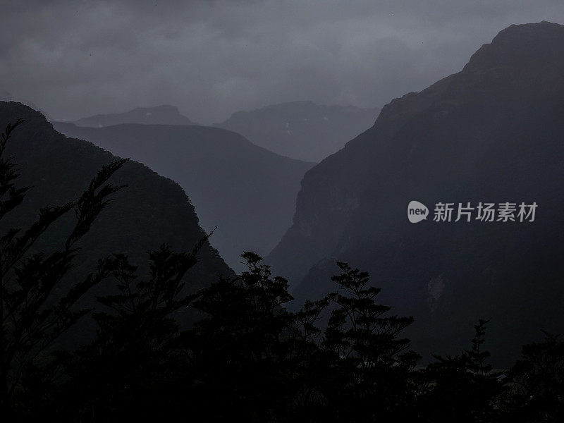 大雨滂沱，从高空往下看，乌云密布的黑暗山谷。路本赛道，阿斯帕山国家公园，新西兰。