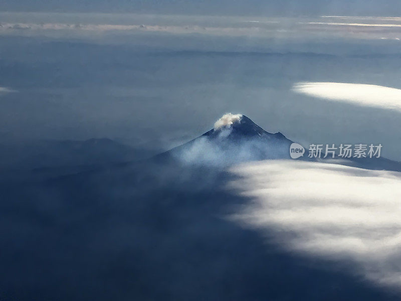 从飞机上，你可以看到群山在阳光下终年被雪和云包围。