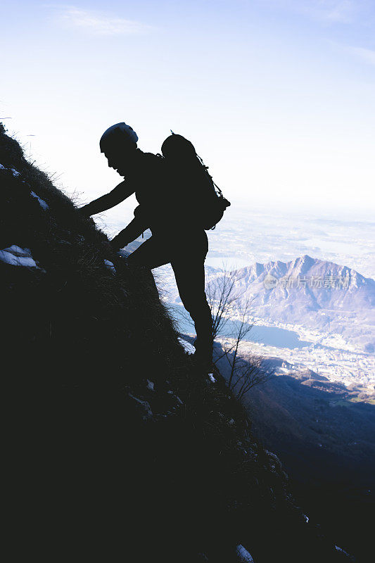 登山运动员沿着山脊攀登，剪影和蓝天