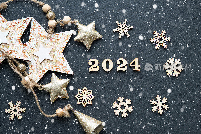 新年快乐木制字母和数字2024在节日的黑色背景与亮片，星星，雪。问候,明信片。日历,封面