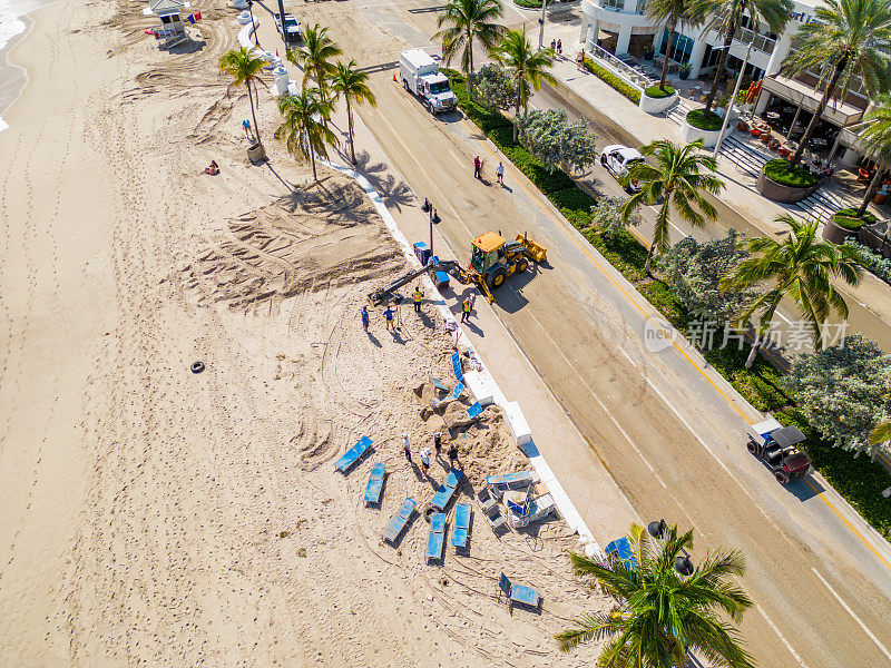飓风妮可过后的劳德代尔堡海滩，清理人员正在清理道路上的沙子