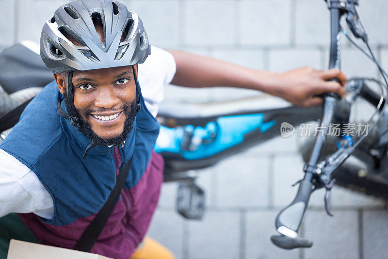 黑人男子，送货自行车和街景从俯视图的物流，货物和快乐的工作。年轻的非洲人，自行车和运输服务带着微笑在户外，头盔和安全在城市