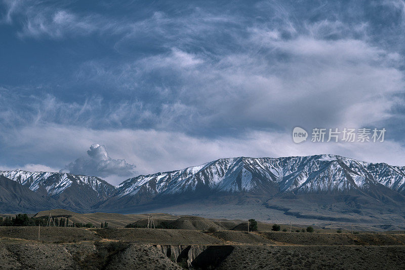 山谷和较低山脉后面的雪山山脊。南天山，贾拉拉巴德地区，吉尔吉斯斯坦