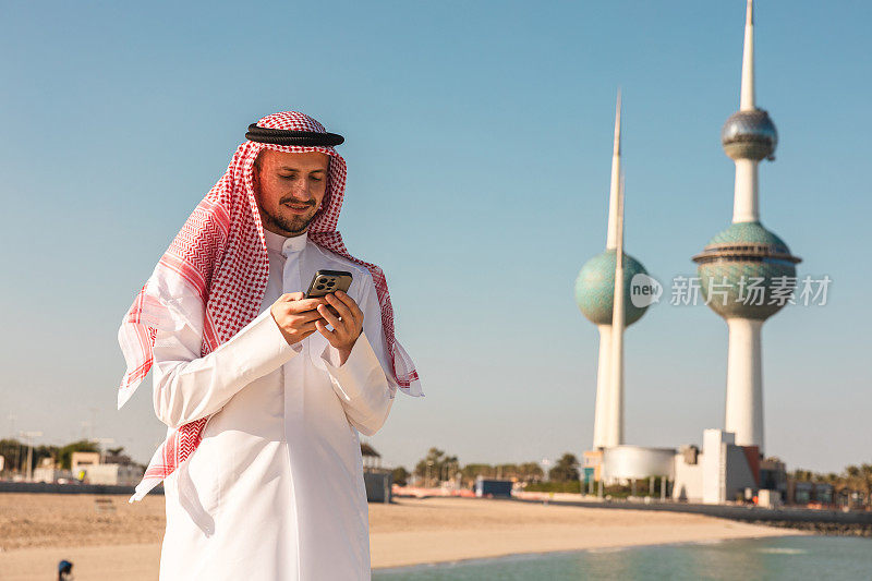 身穿传统服装的科威特年轻人在户外玩手机