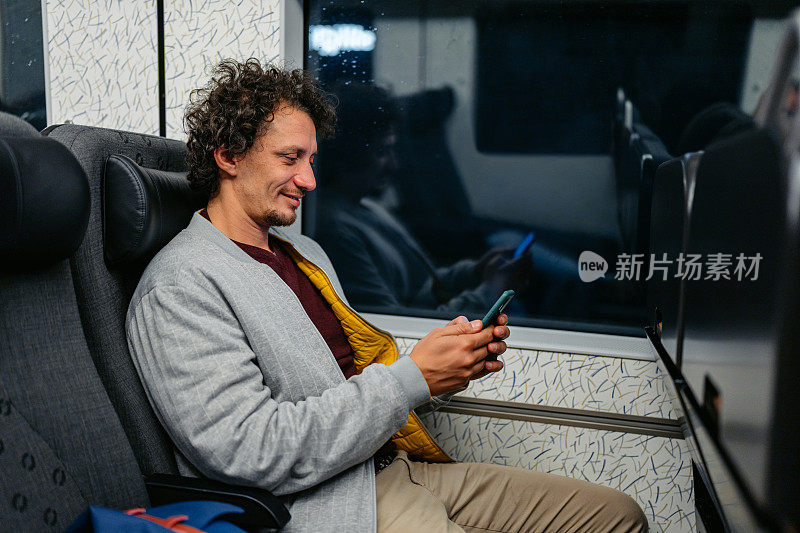 成年男子晚上在马尔默的火车上玩手机