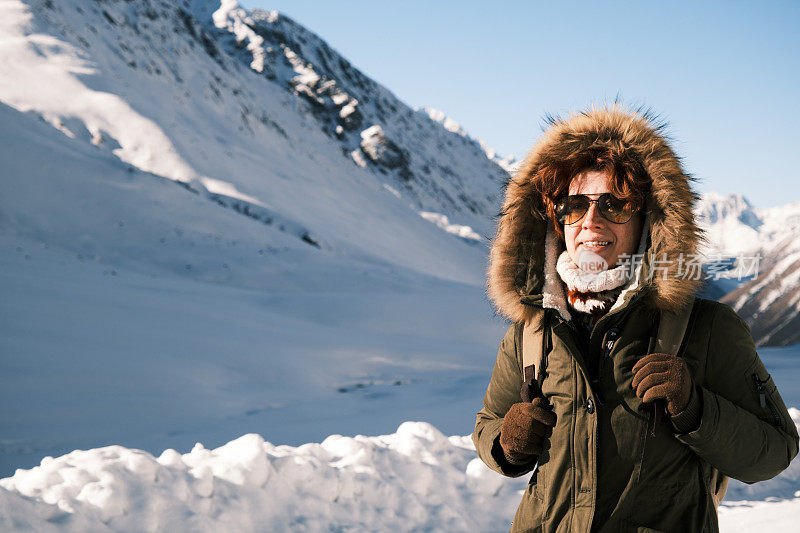 女(46岁)游客在冬季观看山口景色(春阿蜀山口，海拔约4000米)。