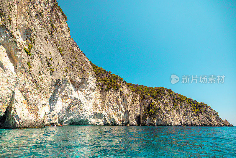 惊人的高岩石悬崖和清澈碧蓝的水在希腊的夏天