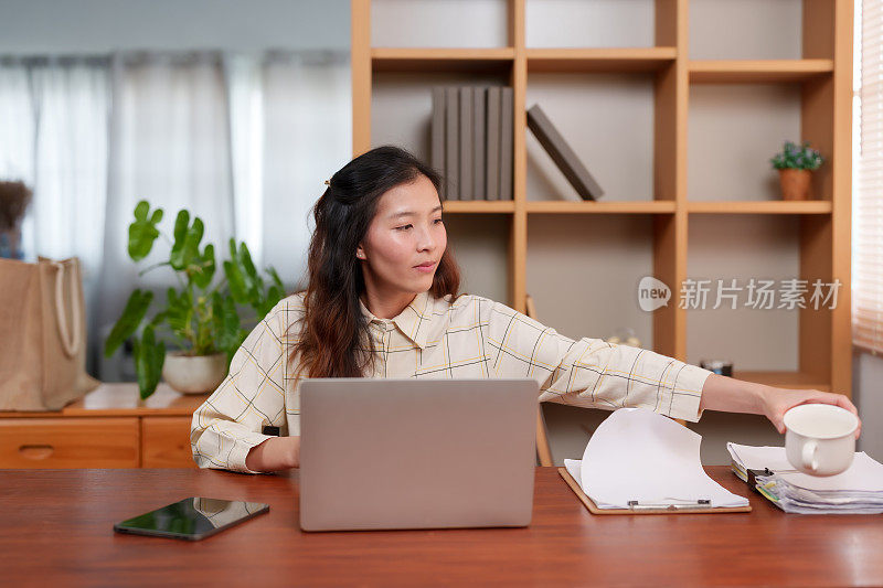 亚洲上班族可以轻松地伸展身体，在舒适的环境中放下笔记本电脑工作，好好休息一下。舒适与专业融合在一起，这位亚洲员工花了一点时间