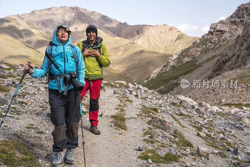 徒步者，年长的女人和男人从塔什拉巴特步行到靠近中国和吉尔吉斯斯坦边境的山口