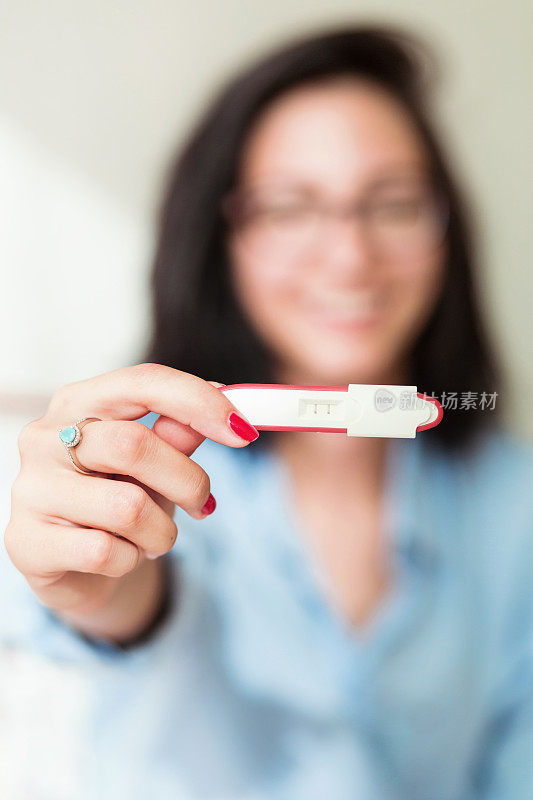 镜头前显示怀孕测试呈阳性的妇女
