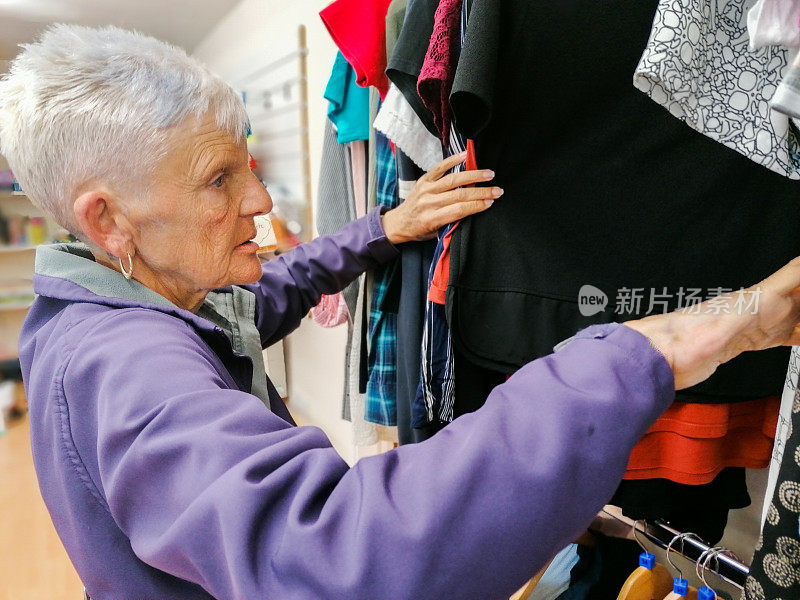 中年妇女在慈善商店看衣服