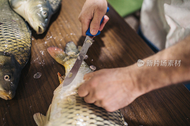 男子在家里的厨房里准备鲤鱼河鱼烹饪健康饮食食品