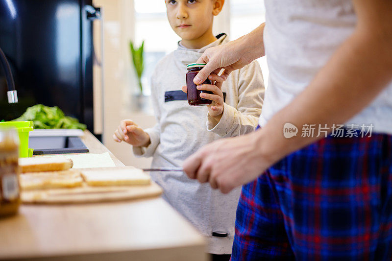 男孩把果酱罐递给他的父亲