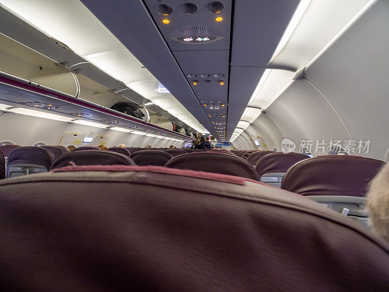 飞机内部，乘客坐在座位上等待起飞