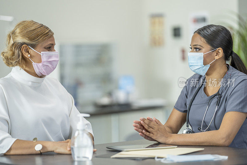 女医生与戴口罩的病人交谈