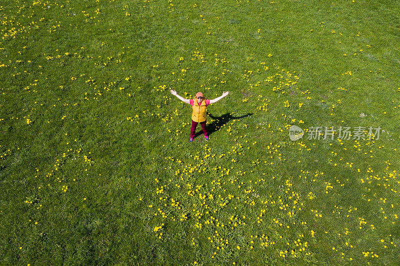 在春天的草地上，女人张开双臂，腾空而起