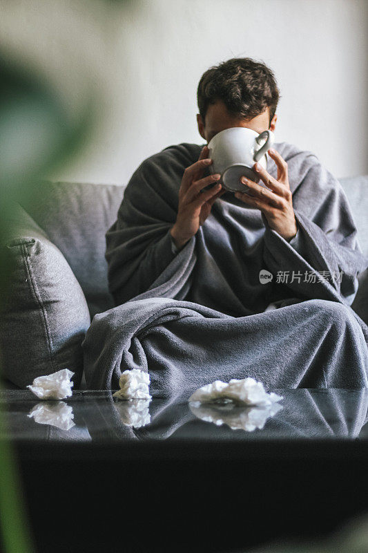 生病的年轻人在喝热饮