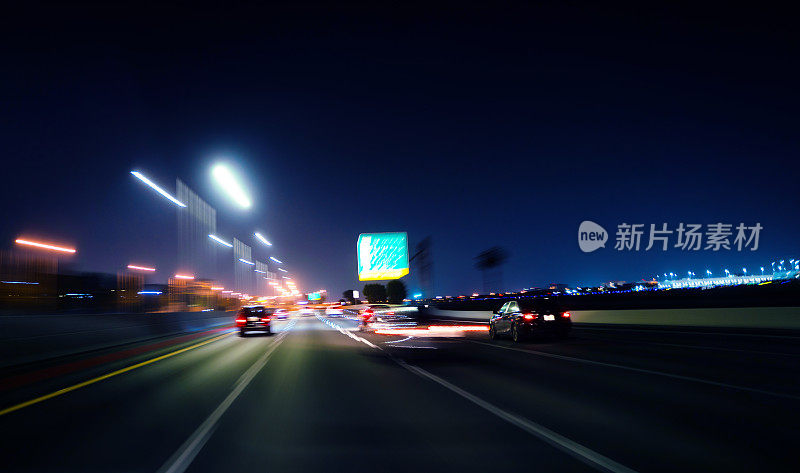 夜晚，在迈阿密高速公路上，汽车被灯光尾随