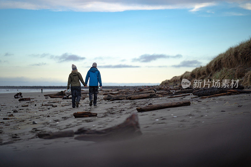 年轻夫妇手持水晶球穿过海滩