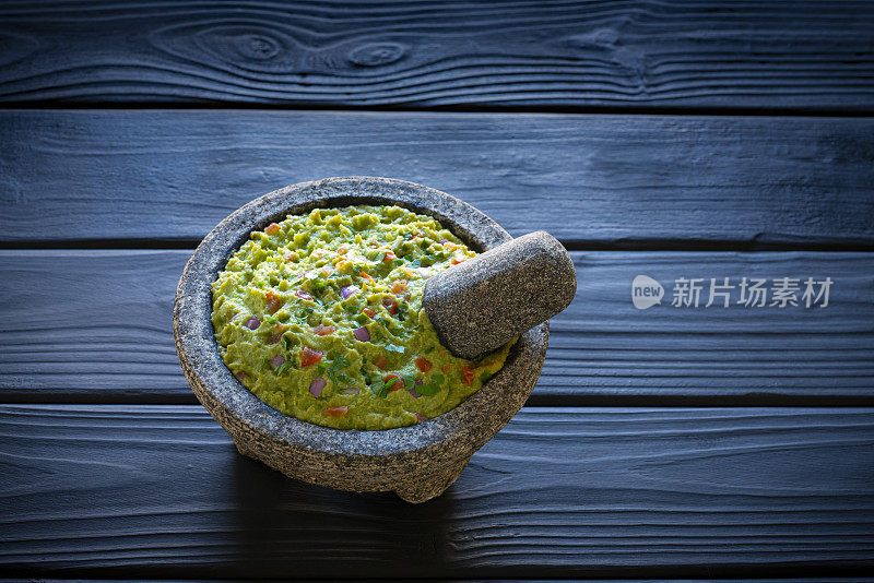 牛油果墨西哥食谱在石头molcajete黑木头背景