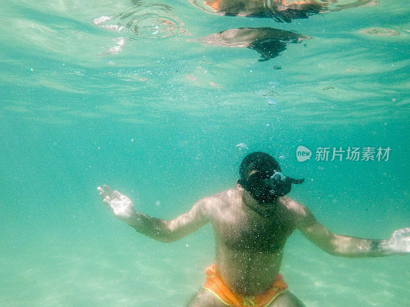 一个年轻人在水下浮潜