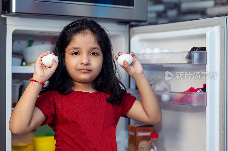 小女孩从冰箱里拿鸡蛋
