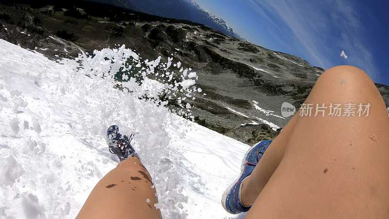 徒步旅行者沿着积雪的山坡跑下去