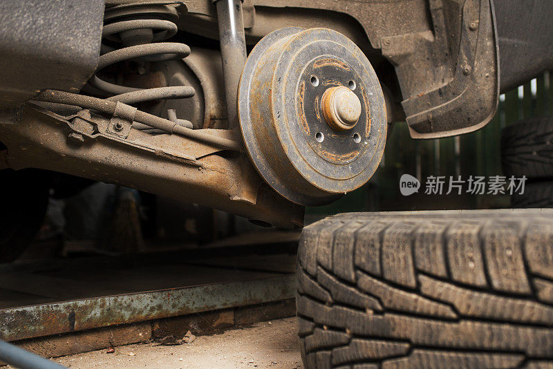 汽车轮胎安装与拆卸车轮。轮毂特写镜头。季节性轮胎改变。空生锈的毂没有车轮。汽车服务理念。