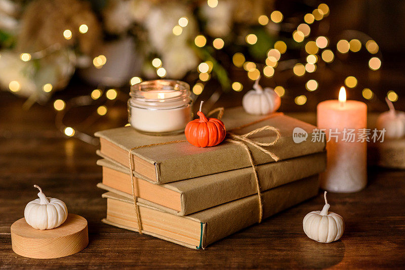 一根燃着的蜡烛放在一张木桌上，前面是一本书，被降半旗