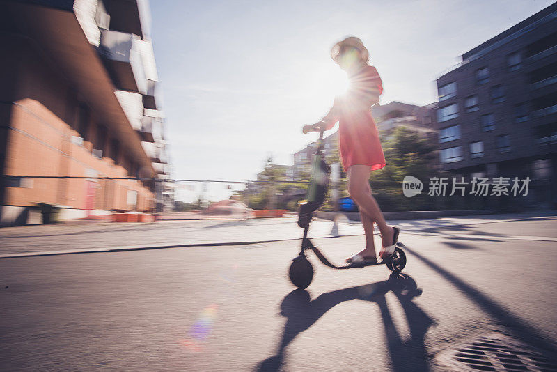 女人骑着电动踏板车穿过城市
