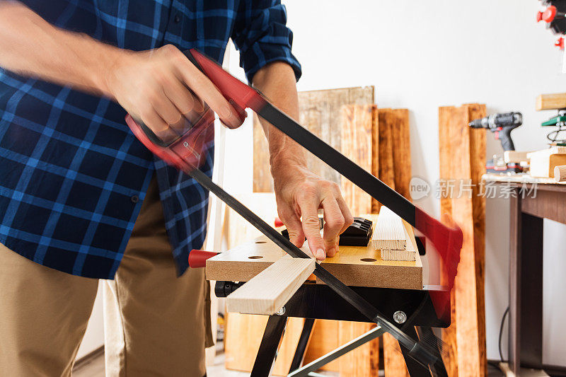木工，用手锯切割木板