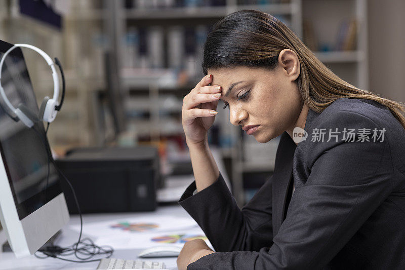 这是一个年轻的商务女性在办公室工作时的沮丧和压力