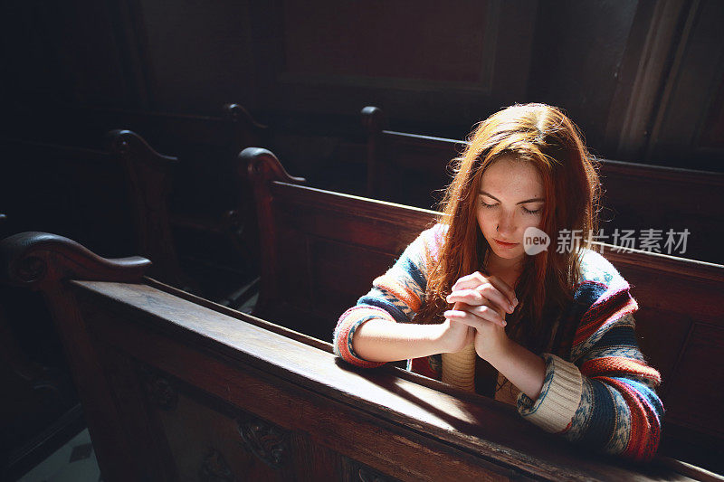 年轻女子在教堂祈祷