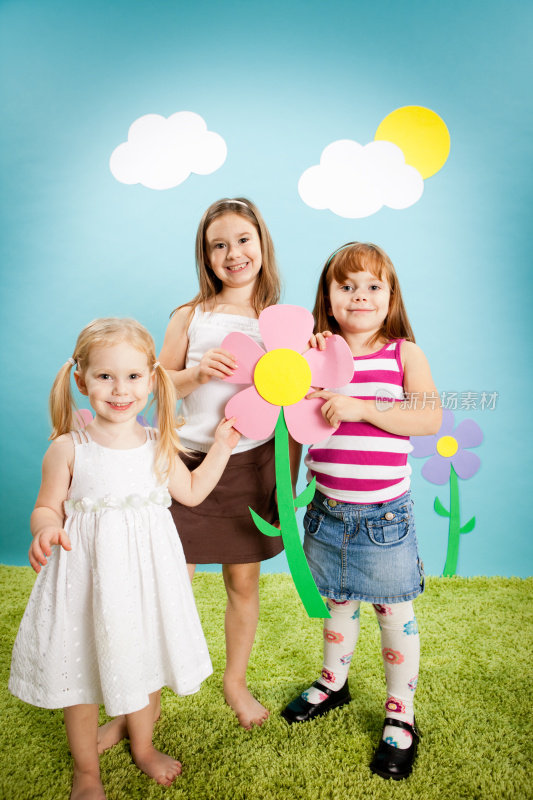 在异想天开的世界里，三个快乐的女孩拿着超大的花