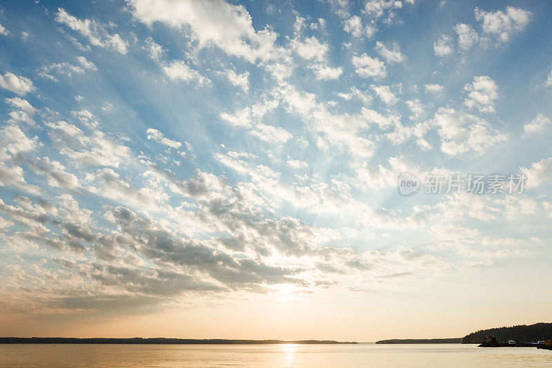 日出时，云和太阳在湖面上照射
