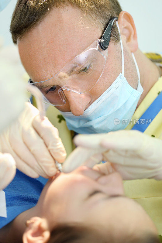 牙科医生在牙科诊所治疗女孩的牙齿
