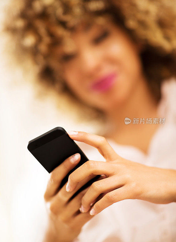 一个女人在手机上发短信的特写。