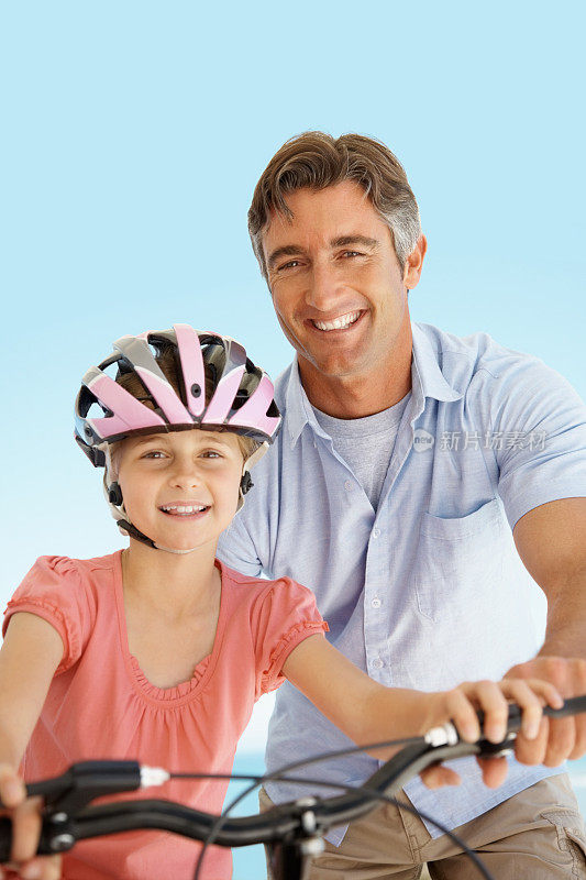 爸爸帮女儿骑自行车