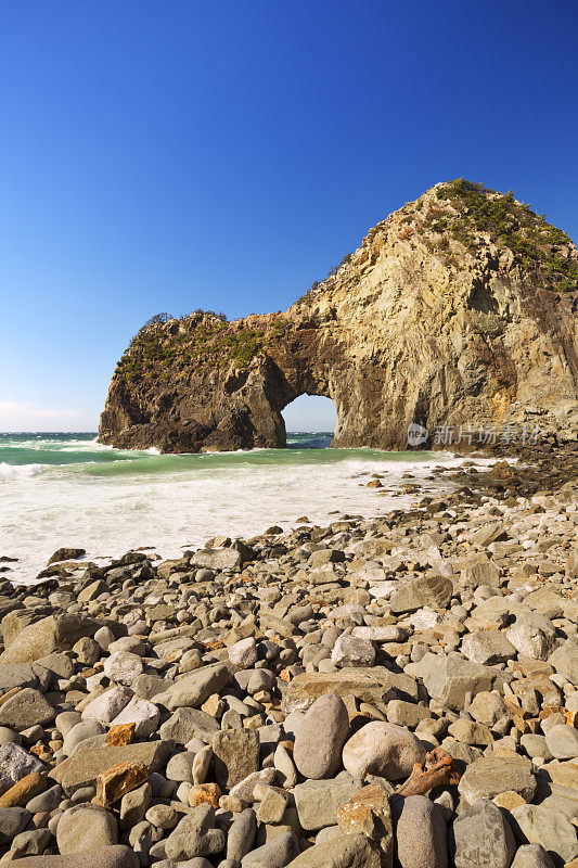 日本伊豆半岛岩石嶙峋的海岸线上的天然拱门