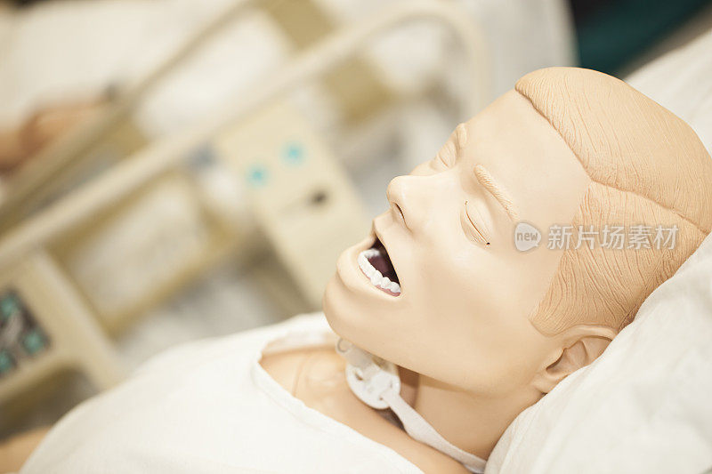 男人体模型躺在医院病床上做气管切开术