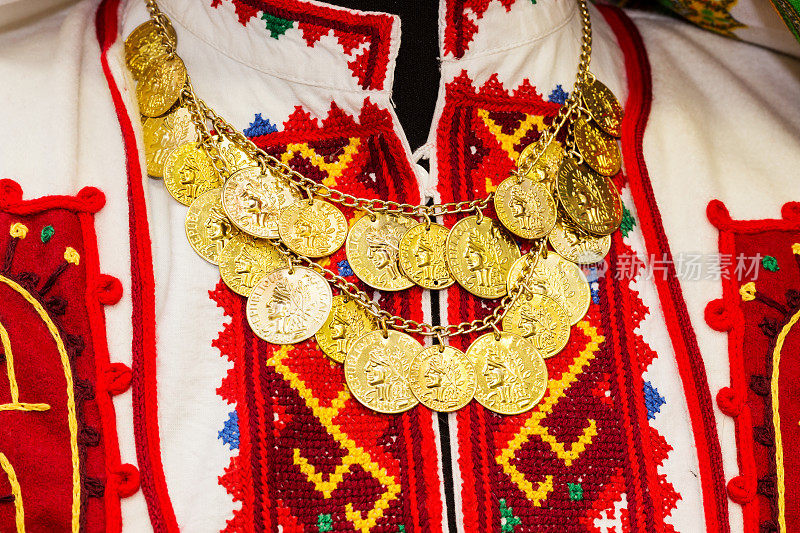 彩色手工刺绣的女衬衫，饰有金币项链。保加利亚的传统工艺品，