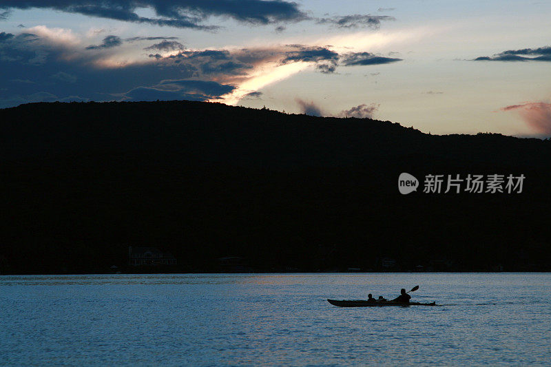 夏天日落时在湖上划皮划艇