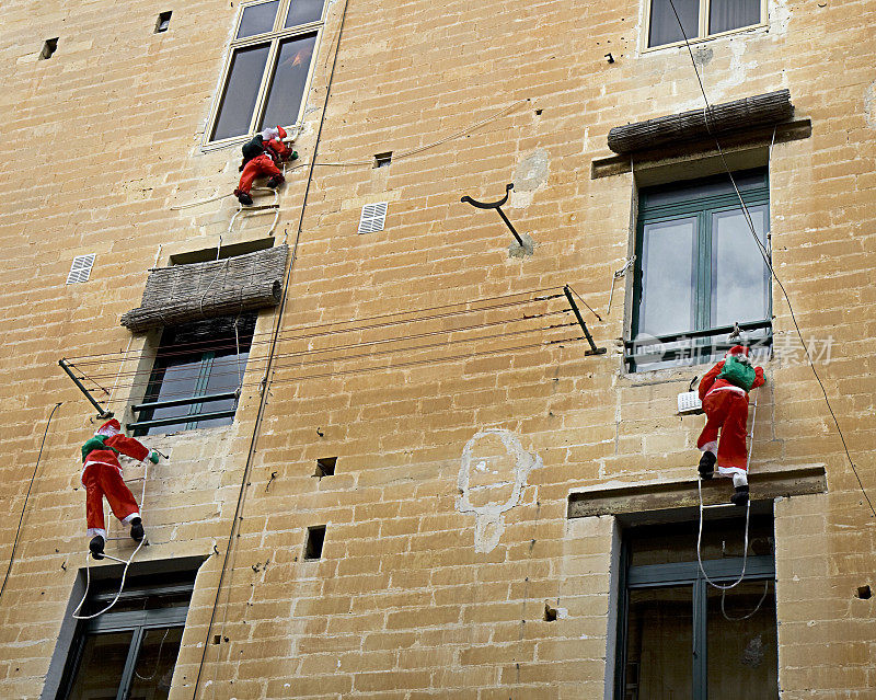 三个圣诞老人在爬墙