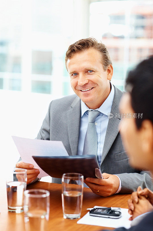 微笑的商人坐在一个会议的同事