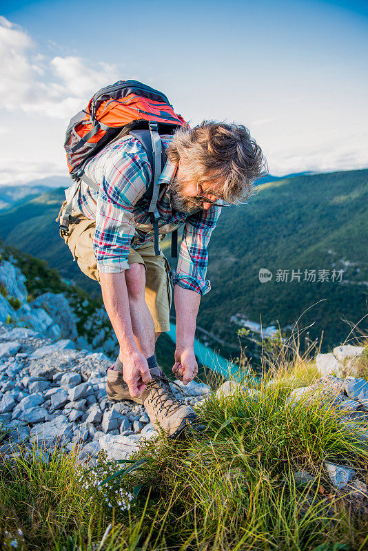 在山上系鞋的老人