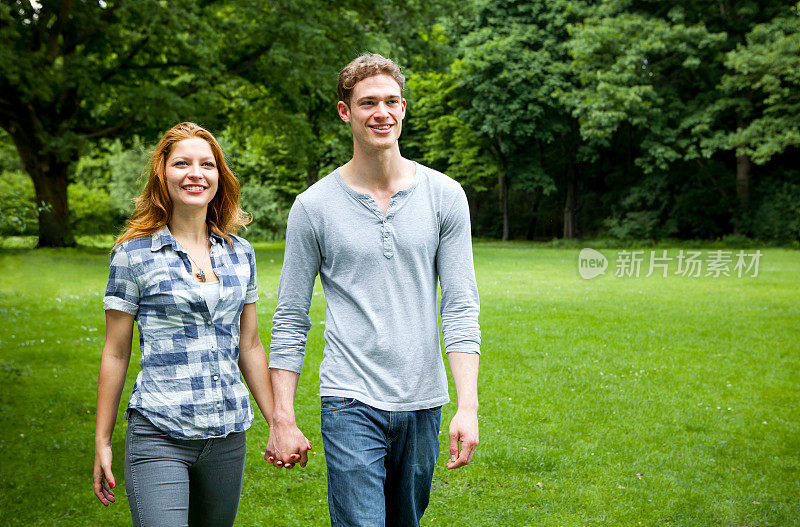 一对浪漫的年轻情侣在公园散步